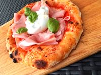 neapolitanische Pizza mit Burrata Prosciutto und frischem Basilikum